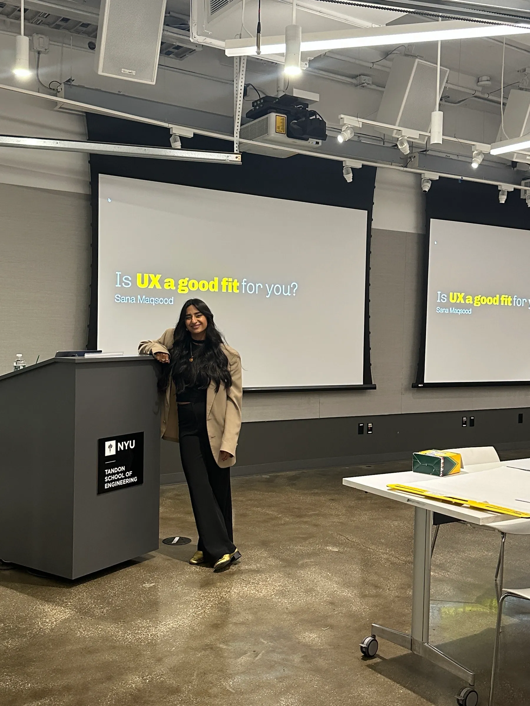 Sana in front of her talk slide, “Is UX a good fit for you?”